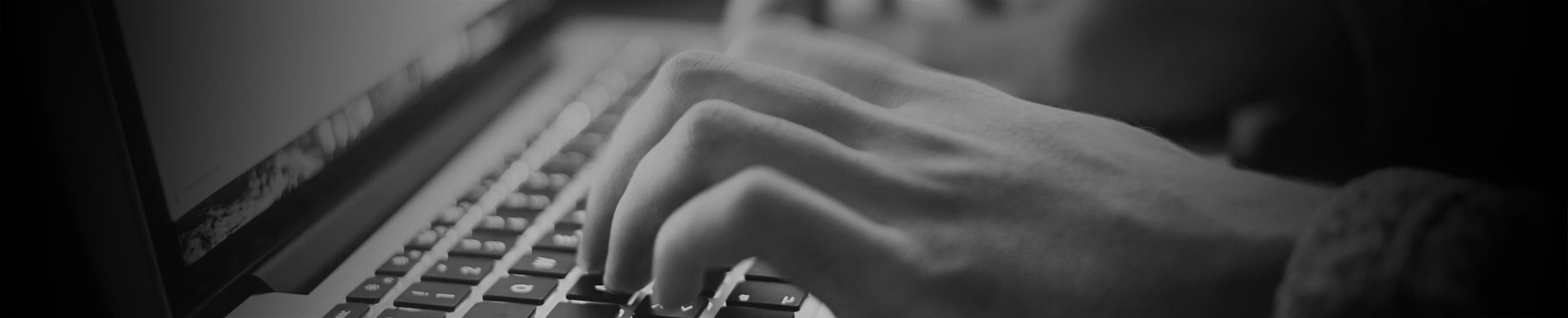 Hænder der taster på en computer